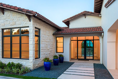 Imagen de fachada de casa blanca mediterránea extra grande de dos plantas con revestimientos combinados, tejado a cuatro aguas y tejado de teja de barro