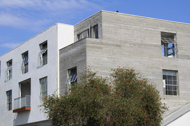 Modern inredning av ett stort vitt hus, med tre eller fler plan, platt tak och tak i metall