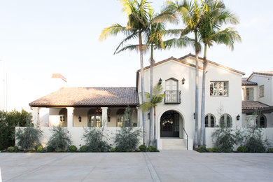 Tuscan white two-story exterior home photo in Los Angeles with a shingle roof