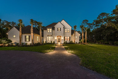 Large traditional beige two-story stucco exterior home idea in Jacksonville with a shingle roof