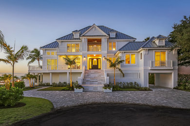 Tropical gray two-story mixed siding house exterior idea in Tampa with a hip roof and a metal roof