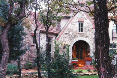 Diseño de fachada beige clásica de tamaño medio de tres plantas con revestimiento de piedra y tejado a dos aguas