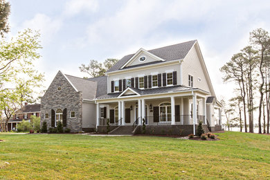 Example of a large country beige two-story wood exterior home design in Other with a shingle roof