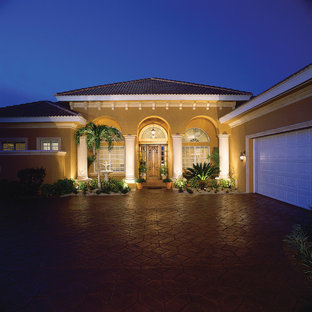 Mid-sized mediterranean beige one-story stucco exterior home idea in Miami with a hip roof