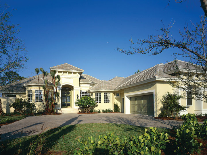 Huge exterior photo of a one-story, tuscan beige home with stucco and a hip roof