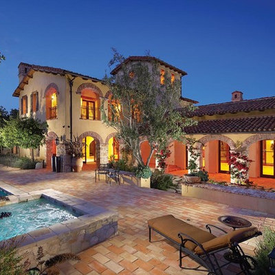Mid-sized tuscan gray two-story stone exterior home photo in Orange County with a tile roof