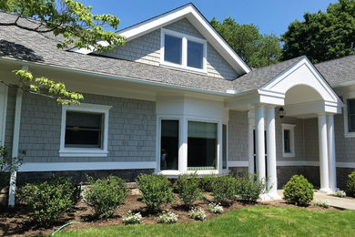 Diseño de fachada de casa gris tradicional grande de dos plantas con revestimiento de madera, tejado de teja de madera y tejado a dos aguas