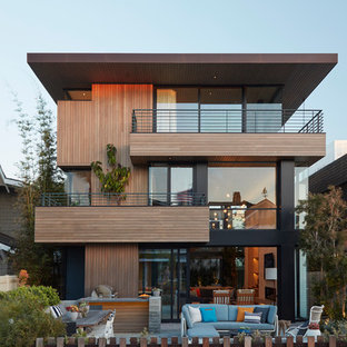 Diseño de fachada de casa marrón, contemporánea, de tres plantas, con revestimiento de madera y tejado plano
