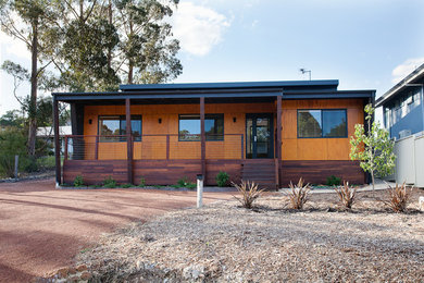 Réalisation d'une façade de maison bleue design de plain-pied avec un toit plat et un revêtement mixte.