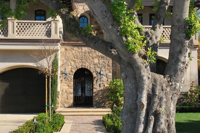 Foto de fachada de casa beige mediterránea de tamaño medio de dos plantas con revestimientos combinados, tejado a cuatro aguas y tejado de teja de barro