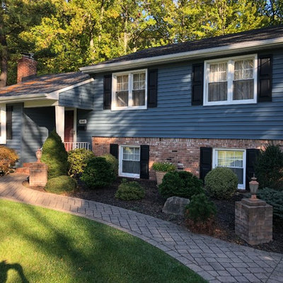 Mid-sized traditional blue two-story wood exterior home idea in New York with a shingle roof