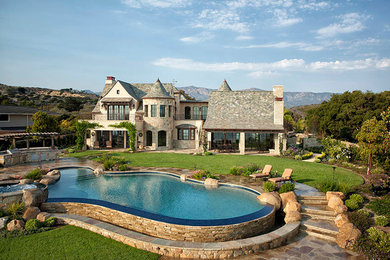 Example of a huge classic beige two-story stucco house exterior design in Santa Barbara with a hip roof and a tile roof