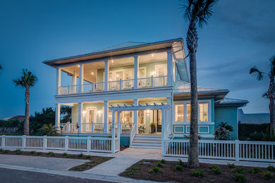 Imagen de fachada de casa azul marinera de tamaño medio de dos plantas con revestimiento de madera, tejado a cuatro aguas y tejado de metal