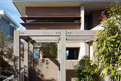 Diseño de fachada de casa marrón actual de tamaño medio de dos plantas con revestimiento de hormigón, tejado plano y tejado de metal