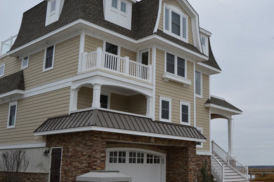 Foto de fachada beige marinera de tres plantas con revestimientos combinados