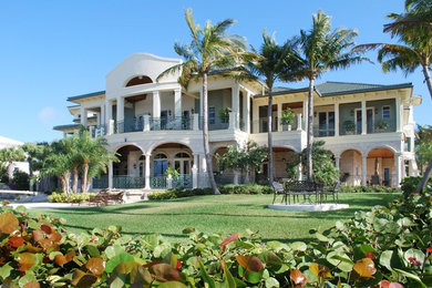 Expansive and green world-inspired two floor house exterior in Miami with stone cladding and a pitched roof.