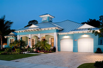Example of an island style blue one-story exterior home design in Miami