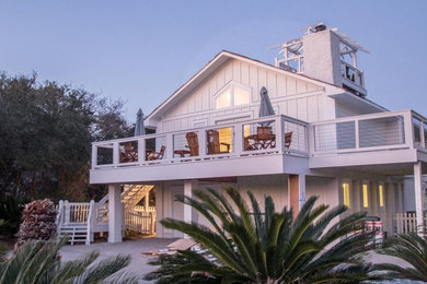 Foto de fachada de casa blanca costera de tamaño medio de dos plantas con revestimiento de madera