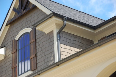 Esempio della facciata di una casa grande marrone american style a due piani con rivestimento in legno e tetto a capanna