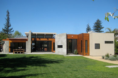 Inspiration pour une très grande façade de maison grise design en stuc de plain-pied avec un toit plat.