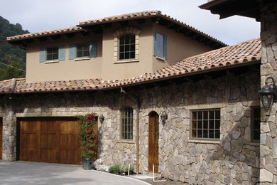Example of an eclectic gray two-story stone exterior home design in San Francisco with a hip roof