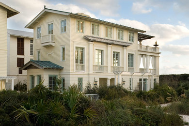 Diseño de fachada beige marinera de tres plantas con tejado a dos aguas