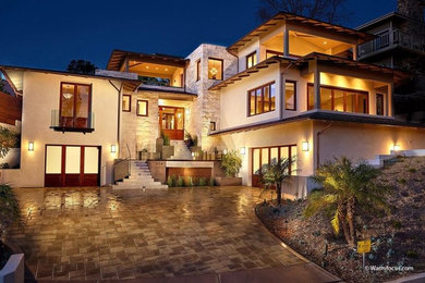 Example of a large trendy beige three-story stucco house exterior design in Other