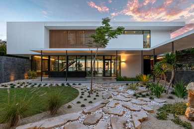 Imagen de fachada de casa blanca moderna grande de dos plantas con tejado plano y revestimiento de estuco