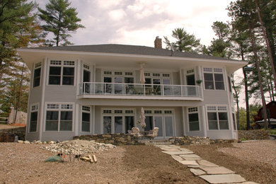 Example of a mid-sized classic gray two-story wood house exterior design in Portland Maine with a hip roof and a shingle roof