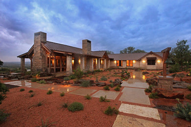 Example of a large minimalist beige one-story stone exterior home design in Austin