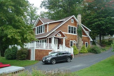 Diseño de fachada de casa de estilo americano de tamaño medio de dos plantas con revestimiento de madera, tejado a dos aguas y tejado de teja de madera