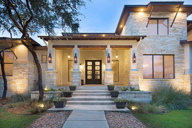 Large transitional white two-story stone house exterior idea in Other with a metal roof
