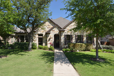 This is an example of a medium sized and beige mediterranean two floor house exterior in Austin with stone cladding.