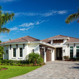Esempio della villa bianca tropicale a un piano di medie dimensioni con copertura in tegole e tetto a padiglione