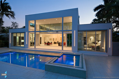 Example of a mid-sized trendy white one-story stucco exterior home design in Miami