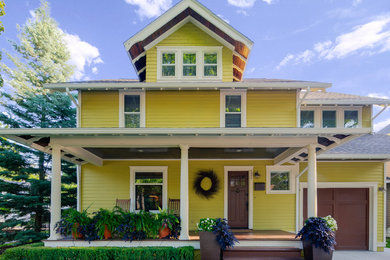 Inspiration for a mid-sized craftsman yellow two-story wood gable roof remodel in Detroit