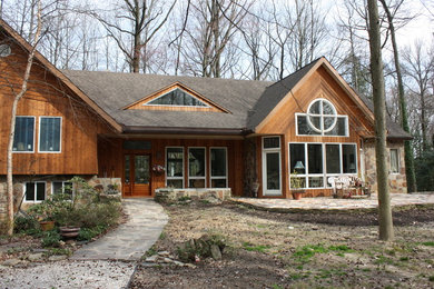 Diseño de fachada marrón rústica de tamaño medio de dos plantas con revestimientos combinados y tejado a dos aguas