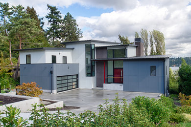 Imagen de fachada contemporánea grande de tres plantas con revestimientos combinados y tejado de un solo tendido