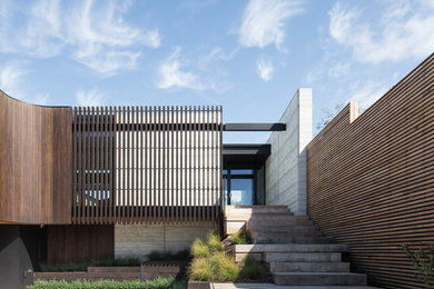 This is an example of a large contemporary two floor detached house in Melbourne with wood cladding and a flat roof.
