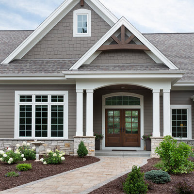 Large arts and crafts brown one-story mixed siding house exterior photo in Milwaukee with a mixed material roof