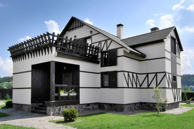 Mittelgroßes, Zweistöckiges Landhausstil Einfamilienhaus mit weißer Fassadenfarbe, Mansardendach und Schindeldach in Moskau