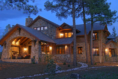 Large mountain style brown two-story stone house exterior photo in Phoenix