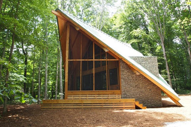 Example of a small minimalist one-story stone gable roof design in Nashville