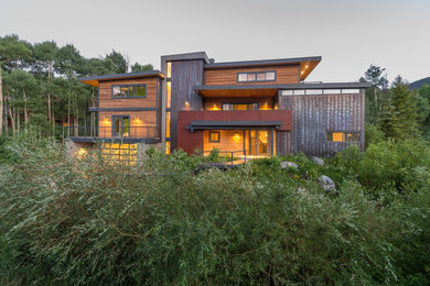Foto de fachada de casa marrón minimalista de tamaño medio de tres plantas con revestimiento de madera y tejado plano