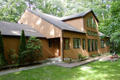 Imagen de fachada de casa marrón rústica grande de dos plantas con revestimiento de madera, tejado a dos aguas y tejado de teja de madera