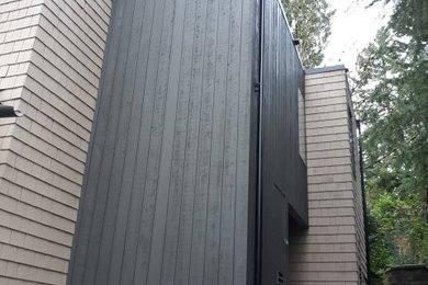 Imagen de fachada de casa gris contemporánea pequeña de dos plantas con revestimiento de madera y tejado plano