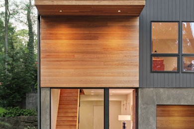 Ejemplo de fachada de casa gris actual de tamaño medio de dos plantas con revestimiento de madera, tejado a cuatro aguas y tejado de teja de madera