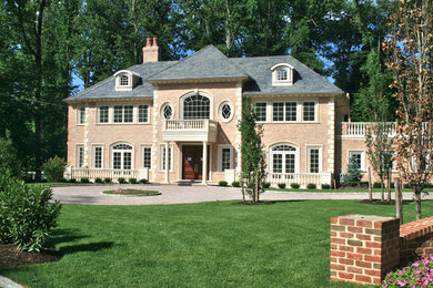 Foto della facciata di una casa grande rossa classica a due piani con rivestimento in mattoni