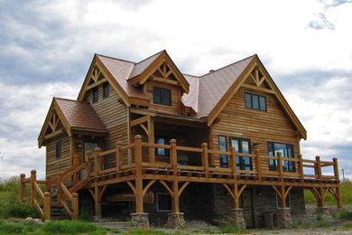 Ejemplo de fachada marrón clásica grande de tres plantas con revestimiento de madera y tejado a dos aguas