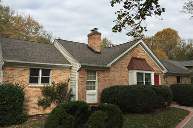 Inspiration for a mid-sized timeless red one-story brick exterior home remodel in DC Metro with a shingle roof